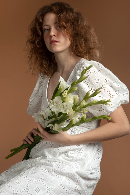 Mujer con hermosas flores de gladiolo