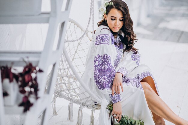 Mujer con hermoso vestido blanco y ramo de flores.