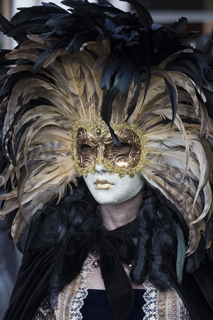 Mujer con un hermoso vestido y una máscara tradicional de Venecia durante el carnaval de fama mundial