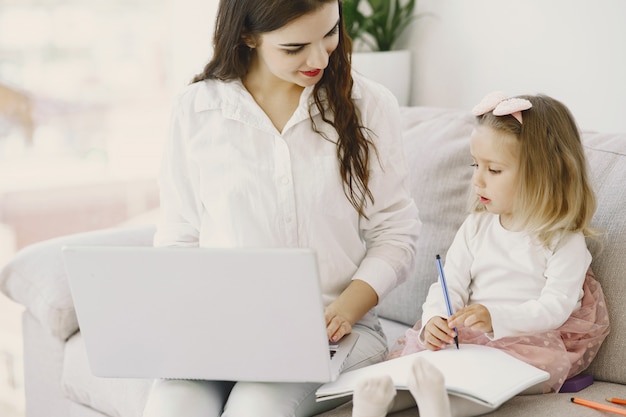 Mujer con hija usando la computadora portátil