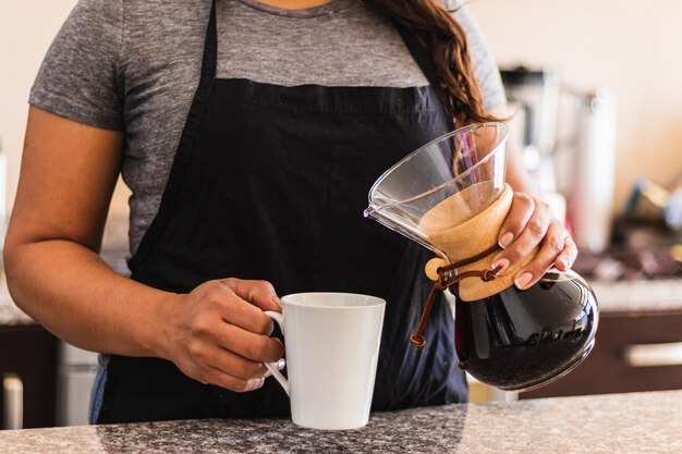 Mujer hispana, barista, verter café