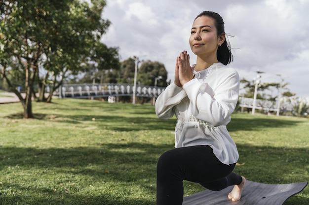 mujer hispana, hacer, yoga, en, un, parque