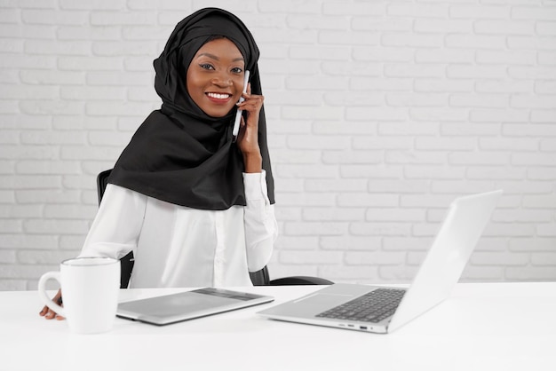 Mujer con hiyab negro trabajando en call center