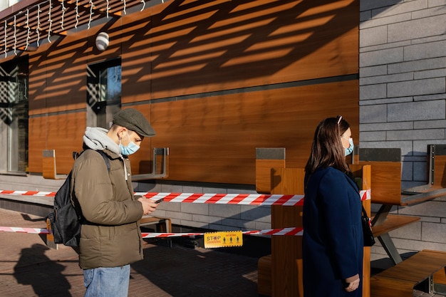 Foto gratuita mujer y hombre en la calle con máscara