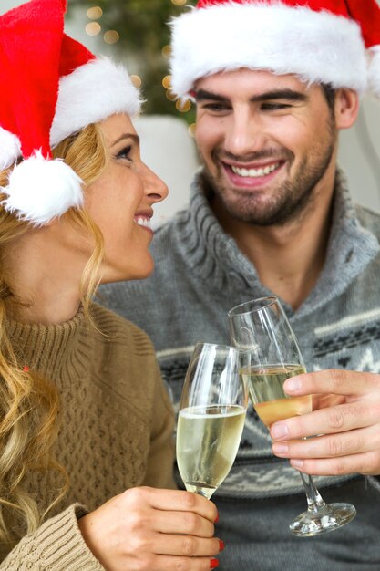 Mujer y hombre con copas de champán mirandose a los ojos