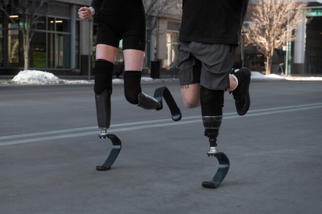 Mujer y hombre con discapacidad en la pierna corriendo en la ciudad