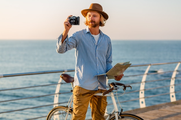 Mujer y hombre enamorado viajando en bicicleta en el mar al atardecer