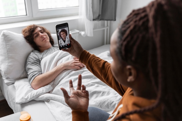 Mujer y hombre hablando con un médico por videollamada.