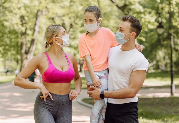 Mujer, hombre y niña caminando en el parque