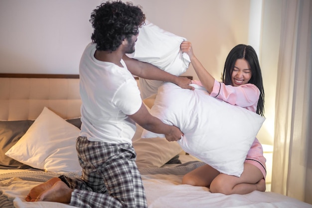 mujer y hombre, pelear, almohadas, cama, en, dormitorio