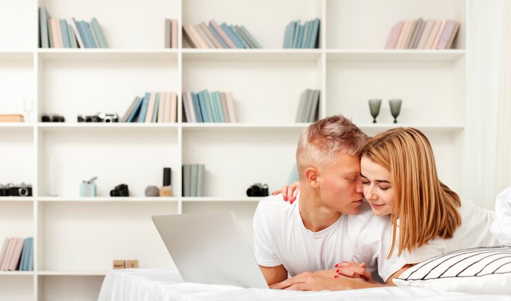 Foto gratuito mujer y hombre relajándose con su laptop en la cama
