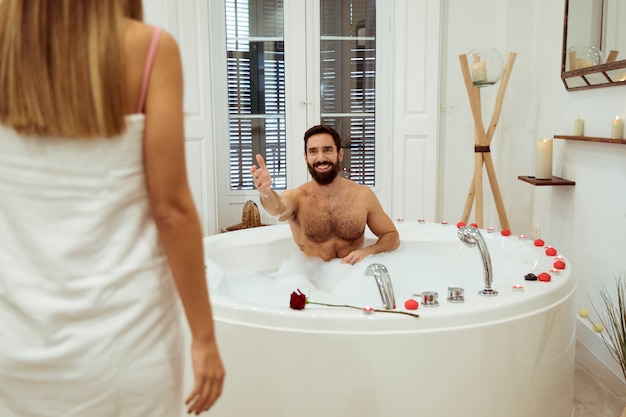 Foto gratuita mujer y hombre sonriente en la bañera de hidromasaje con espuma