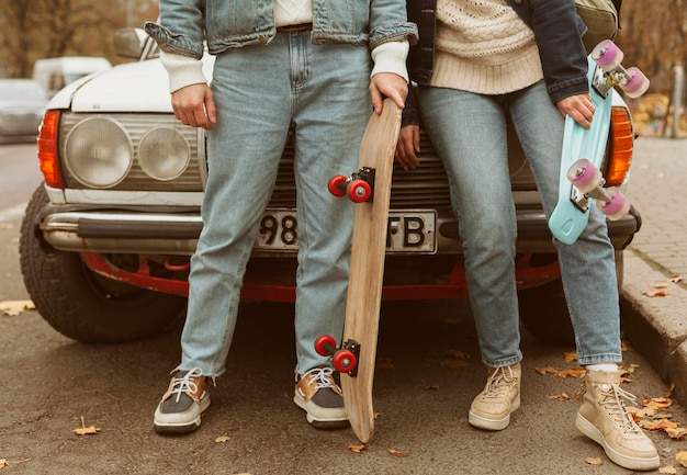 Foto gratuita mujer y hombre sosteniendo sus patinetas