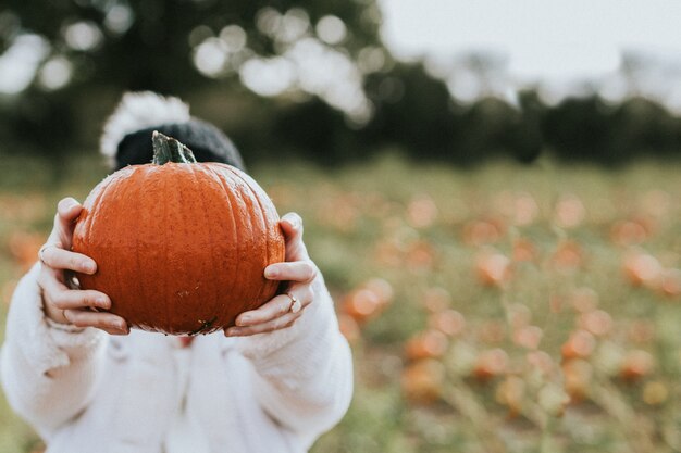 Mujer en un huerto de calabazas antes de Halloween