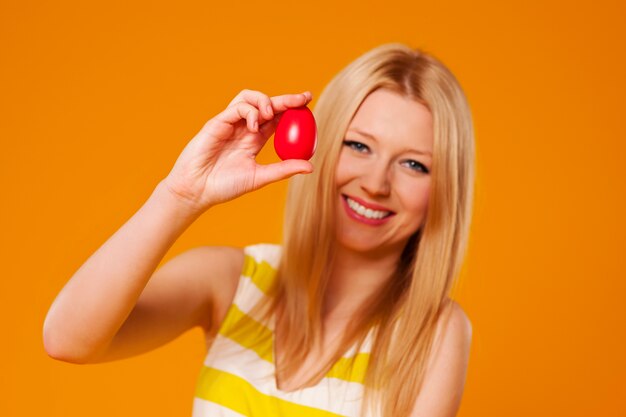 Mujer con huevo de pascua rojo