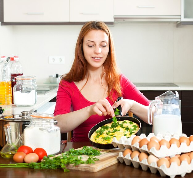 Mujer con huevos revueltos en casa