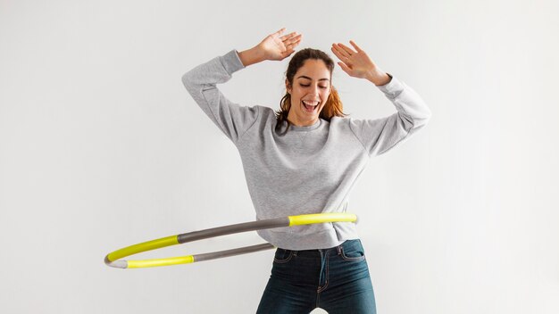 Mujer con hula hoop en casa y divertirse