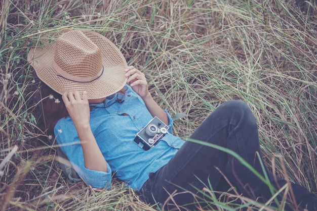 Foto gratuita mujer inconformista joven tumbado en el campo de verano después de la toma de fotos.