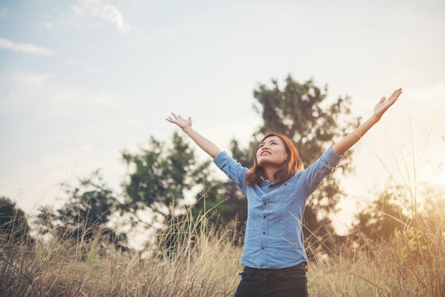 mujer inconformista sonrisa disfrutar con brazo elevador aire fresco en el campo de verano, filtro de tono de época.