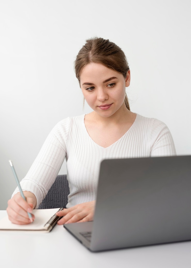 Foto gratuito mujer independiente en escritorio escribiendo en agenda
