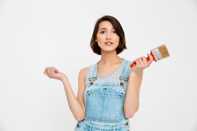 La mujer independiente repara ella misma en casa, sostiene el pincel