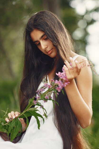 Mujer india con pelo largo. Dama con un vestido azul. Chica con naturaleza virgen.