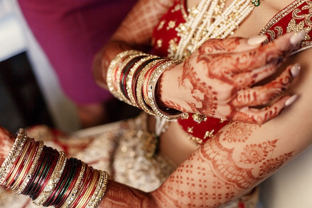 La mujer india sostiene sus manos cubiertas con mehndi