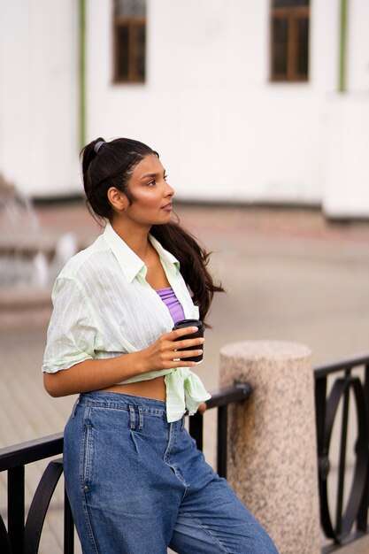 Mujer india de tiro medio sosteniendo una taza de café