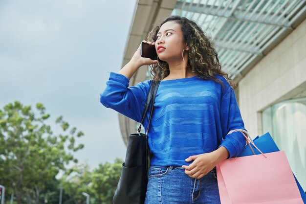 Mujer indonesia hablando por teléfono durante las compras