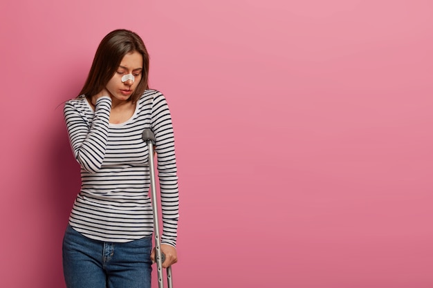 Foto gratuita mujer infeliz toca el cuello de dolor, sufre tras terrible incidente