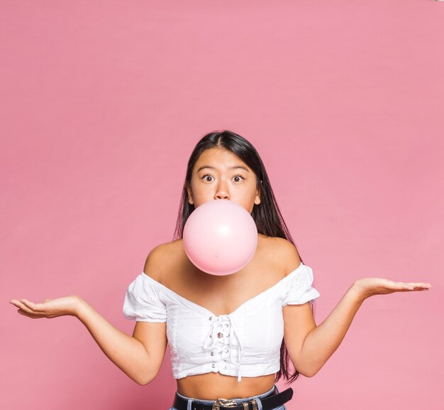 La mujer infla un globo rosado