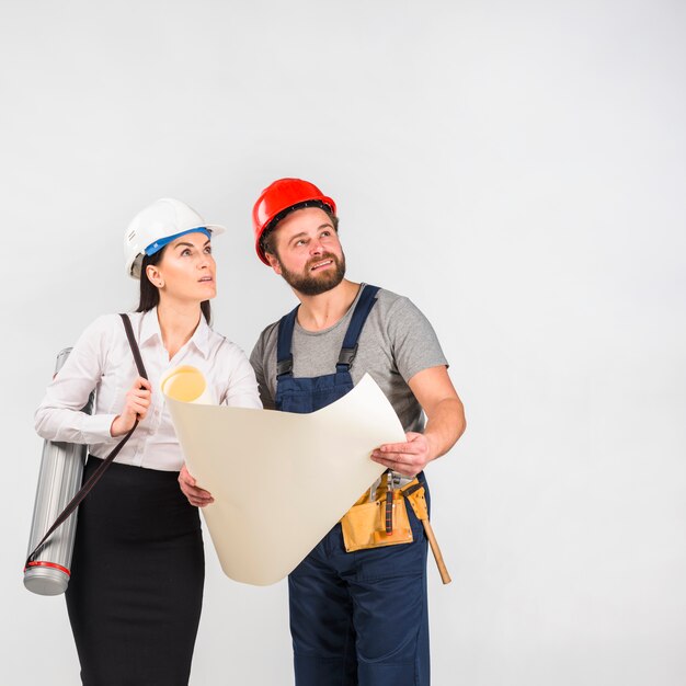 Mujer ingeniero y constructor discutiendo proyecto mirando hacia arriba