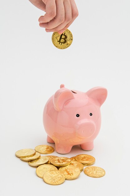 Mujer insertando un bitcoin en una alcancía rosa