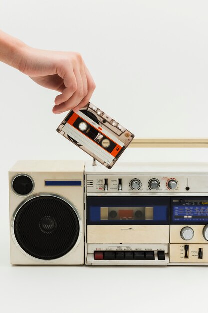 Mujer insertando una cinta de cassette en una radio vintage