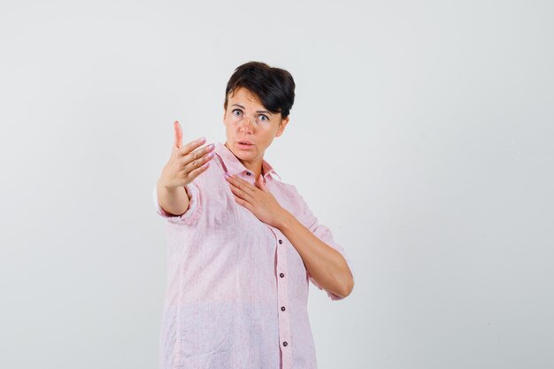 Mujer invitando a venir en vista frontal de la camisa rosa.