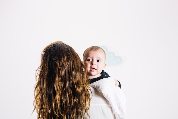 Foto gratuita mujer irreconocible abrazando bebé lindo