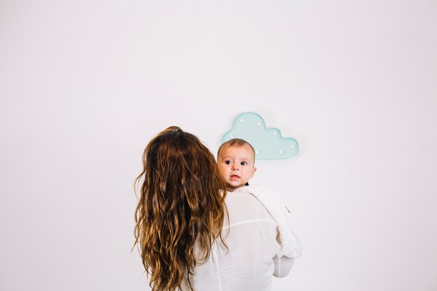 Foto gratuita mujer irreconocible con bebé encantador