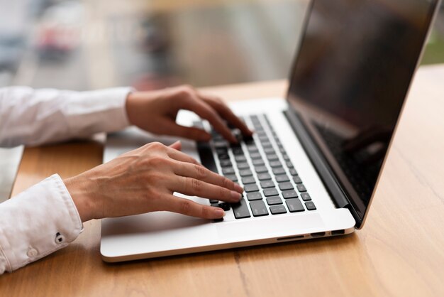 Mujer irreconocible escribiendo en la computadora portátil