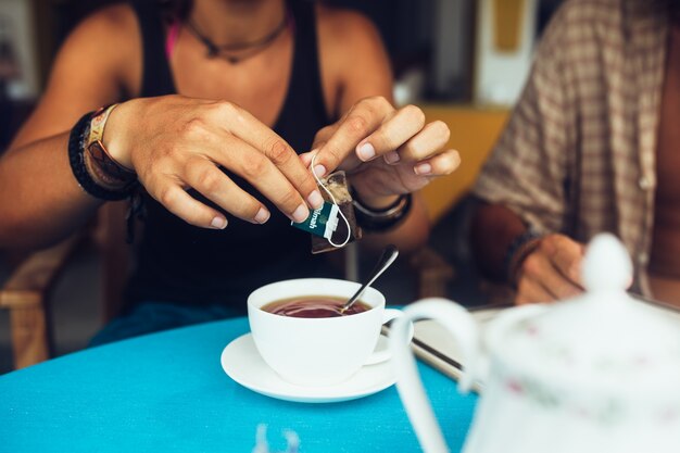 Mujer irreconocible tomando el té