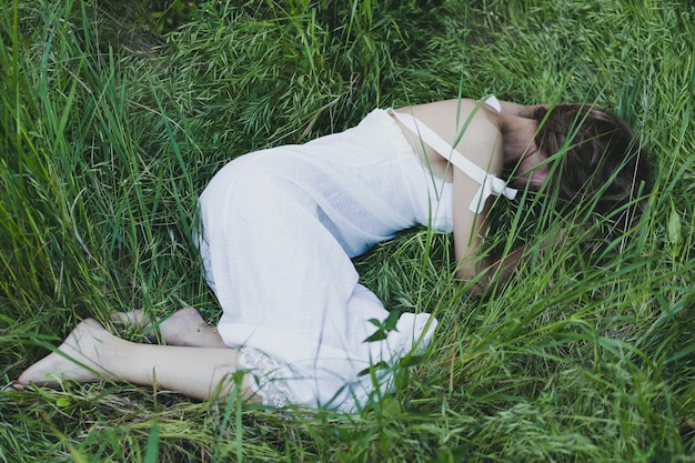 Mujer irreconocible tumbado en la hierba