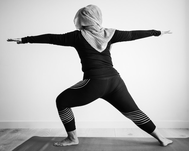 Foto gratuita mujer islámica haciendo yoga en la habitación