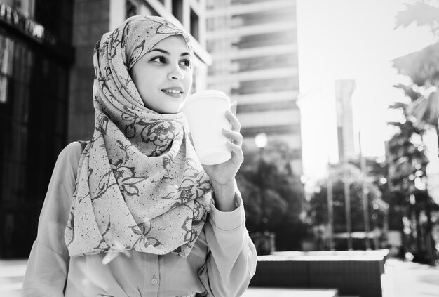 Mujer islámica tomando café en la ciudad