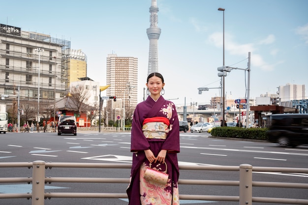 Mujer japonesa celebrando el día de la mayoría de edad y posando en la ciudad
