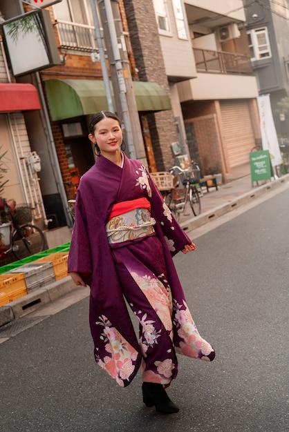 Foto gratuita mujer japonesa celebrando el día de la mayoría de edad y posando en la ciudad