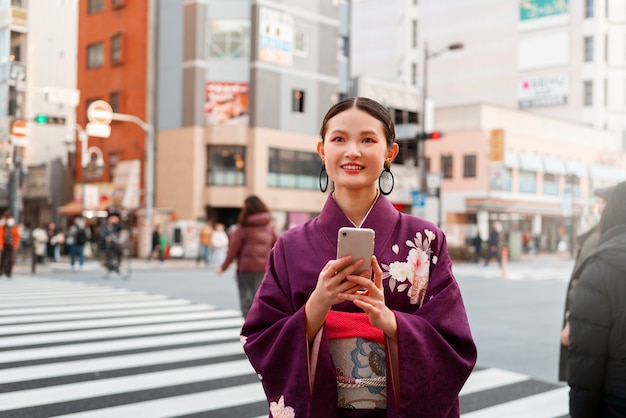 Foto gratuita mujer japonesa celebrando el día de la mayoría de edad y posando en la ciudad