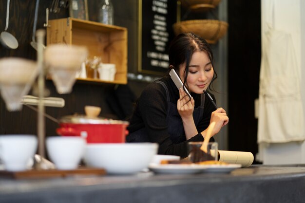 Mujer japonesa hablando por teléfono inteligente en un restaurante