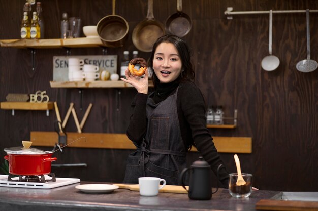 Mujer japonesa posando mientras sostiene un donut