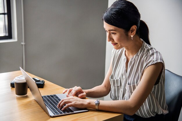 Mujer japonesa que trabaja en una computadora portátil