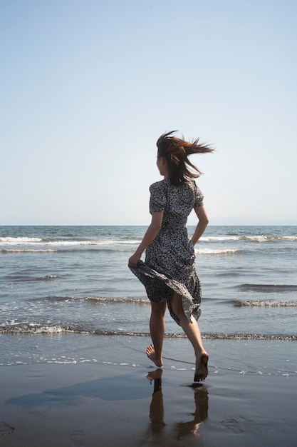 Foto gratuita mujer japonesa de tiro completo en la playa