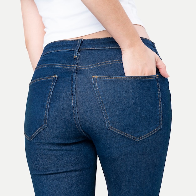 Foto gratuita mujer en jeans azul con la mano metida en el bolsillo, vista trasera, sesión de fotos de moda